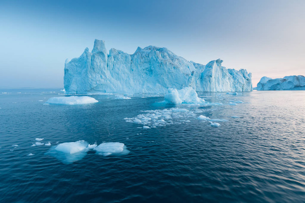 Grote ijsbergen van verschillende vormen in de Disko Bay, West Groenland. Hun bron is bij de Jakobshavn gletsjer. Dit is het gevolg van de opwarming van de aarde en de rampzalige ontdooiing van het ijs.  - Foto, afbeelding