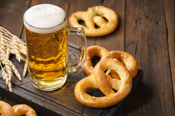 A mug of lager beer with german pretzels. - Fotoğraf, Görsel