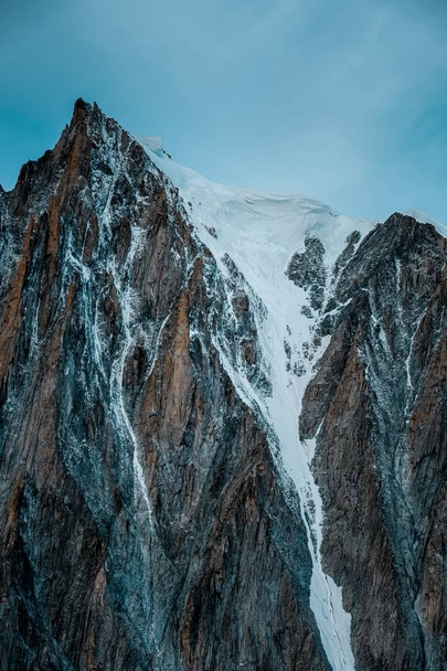 Vertical shot of a snowy mountain with a clear sky in the background - Photo, image