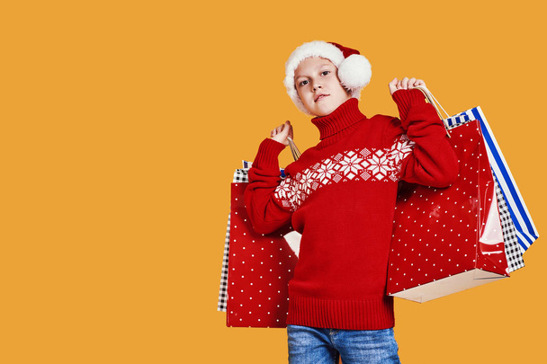 Positive boy in Santa hat with presents - Zdjęcie, obraz