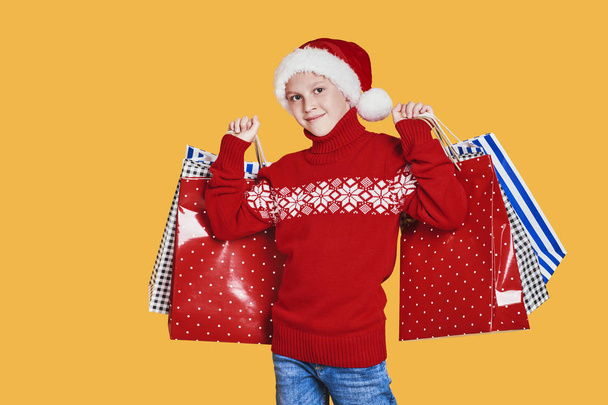 Positive boy in Santa hat with presents - Zdjęcie, obraz