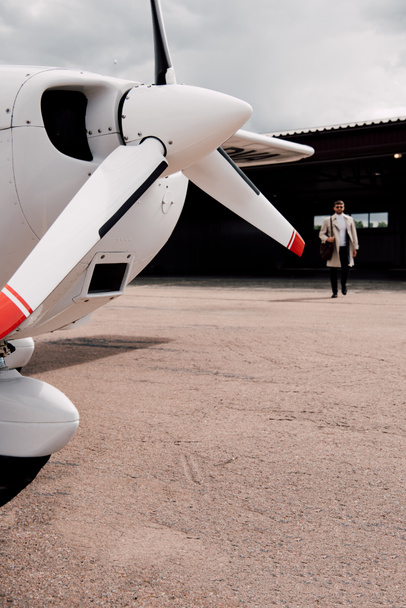Προβολή πλήρους μήκους του ανθρώπου σε επίστρωση με τσάντα και αεροπλάνο στο προσκήνιο - Φωτογραφία, εικόνα