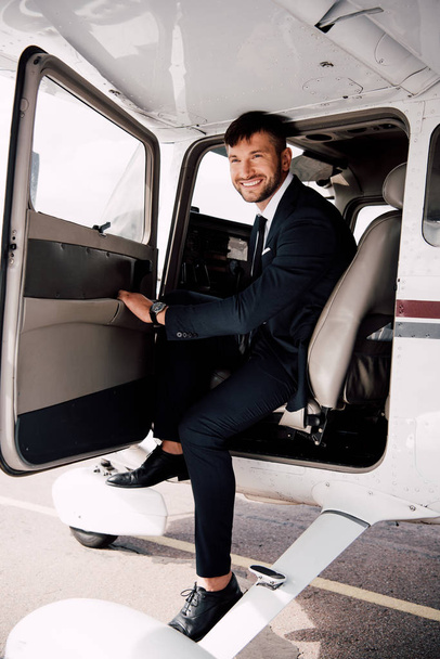 uomo d'affari barbuto sorridente in abbigliamento formale seduto in aereo
 - Foto, immagini