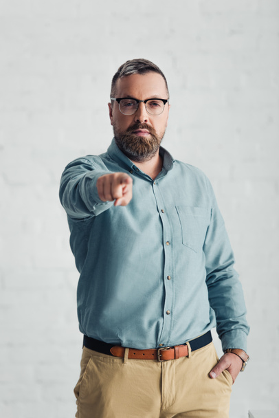 handsome businessman in shirt pointing with finger and looking at camera  - Photo, Image