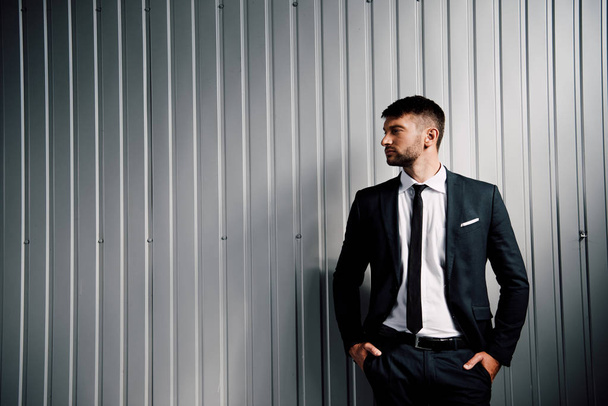 confident businessman in formal wear standing with hands in pockets - Fotoğraf, Görsel