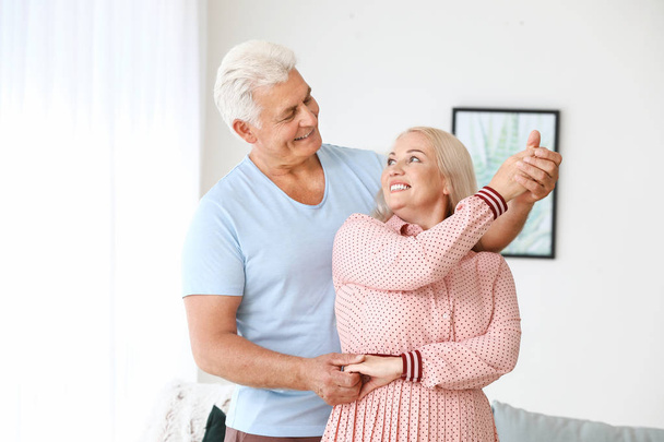 Happy mature couple dancing at home - 写真・画像