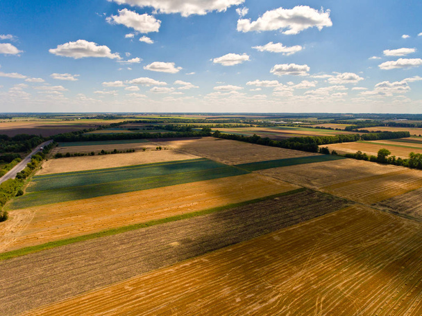 Bela vista aérea de campos agrícolas e céu azul com nuvens brancas
. - Foto, Imagem