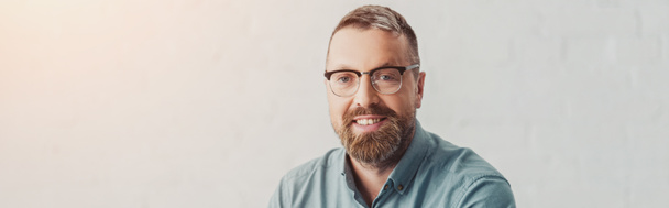 panoramic shot of handsome businessman in shirt and glasses looking at camera  - Fotografie, Obrázek