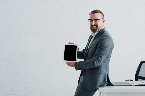 guapo hombre de negocios en ropa formal sosteniendo tableta digital con espacio de copia
 - Foto, imagen