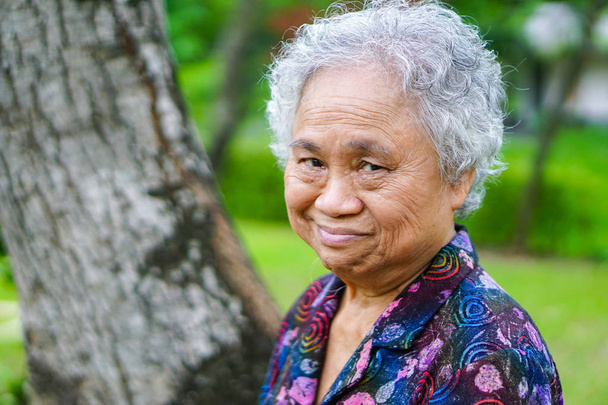 asiatische Seniorin oder ältere Dame achtzig Jahre mit strahlendem Lächeln im Park: gesunde starke Menschen. - Foto, Bild