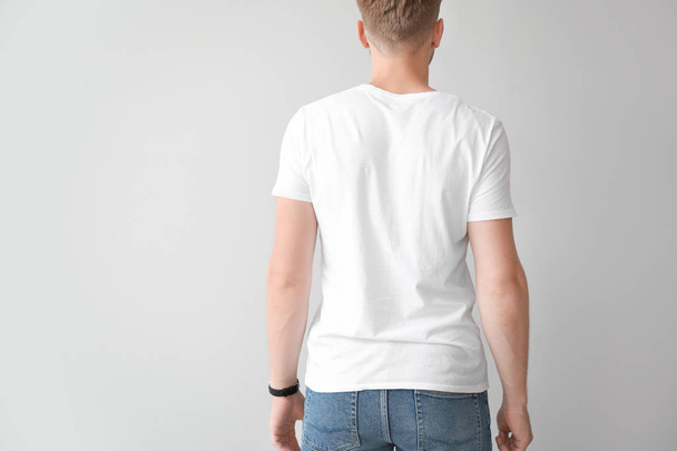 Man in stylish t-shirt on light background, back view - Fotó, kép