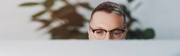 colpo panoramico di uomo in occhiali distogliendo lo sguardo in ufficio
  - Foto, immagini