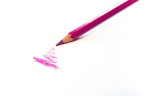 Single pink pencil draws on a white surface isolated on white. Supplies for artists and schools. - Photo, Image