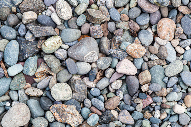 Zbliżenie kamieni rzecznych wielokolorowe szare, brązowe, białe kolory. tekstura, wzór kamieni o różnych rozmiarach - Zdjęcie, obraz