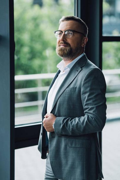 handsome businessman in formal wear and glasses looking away  - Fotoğraf, Görsel