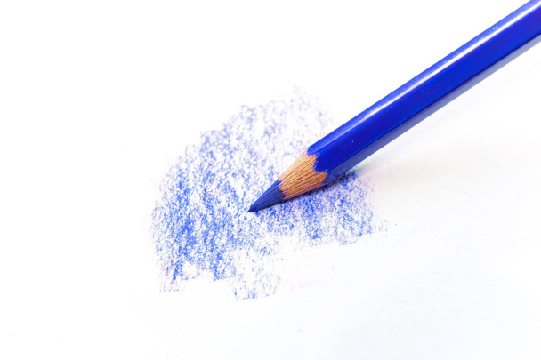 Ένα μπλε μολύβι αντλεί από μια λευκή επιφάνεια απομονωμένη σε λευκό. Προμήθειες για καλλιτέχνες και σχολεία. - Φωτογραφία, εικόνα