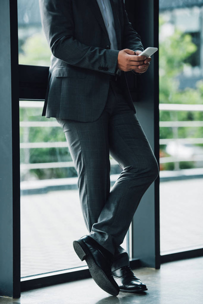 cropped view of businessman in formal wear holding smartphone  - Φωτογραφία, εικόνα