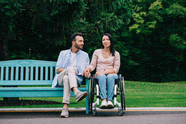 jóképű férfi boldog fogyatékos nő pihen a parkban együtt - Fotó, kép