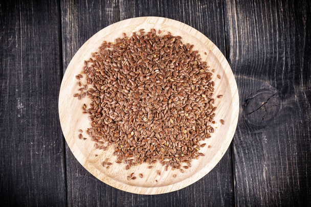 Las semillas de lino en un plato de madera
 - Foto, imagen
