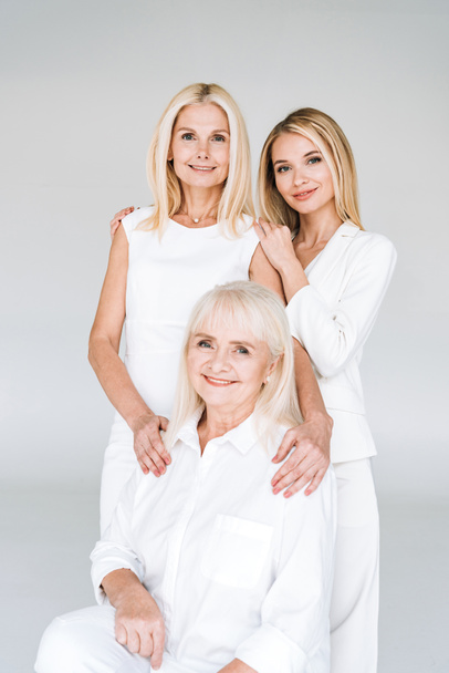 beautiful three generation blonde women isolated on grey - Foto, afbeelding