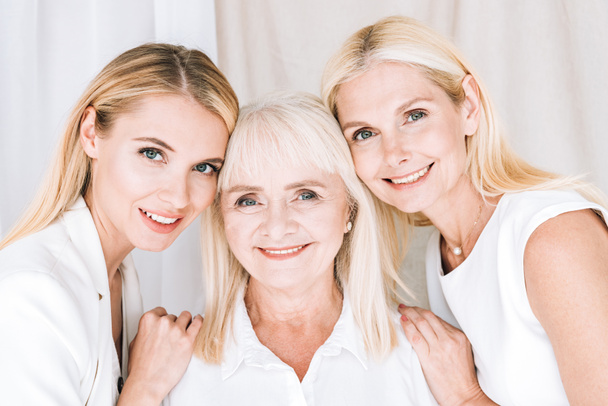 elegant three-generation blonde women in total white outfits - Foto, afbeelding