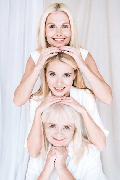happy elegant three-generation blonde women in total white outfits - Photo, image