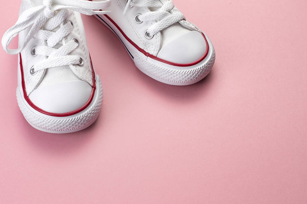 Photo of white sneakers over pink background. - Foto, imagen