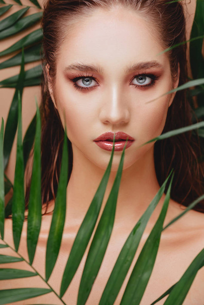 Portrait of young and beautiful woman in tropical leaves. - Photo, Image