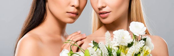cropped view of  blonde and brunette naked women with flowers isolated on grey, panoramic shot - Fotografie, Obrázek