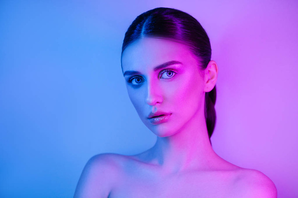 High Fashion vrouw in kleurrijke heldere Neon UV blauw en paars lichten, poseren in Studio - Foto, afbeelding