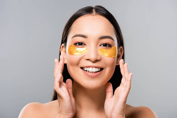 happy naked asian woman with eye patches on face isolated on grey - Zdjęcie, obraz