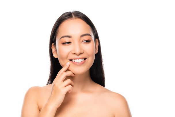 усміхнена красива азіатська жінка з білими зубами дивиться ізольовано на білому
 - Фото, зображення