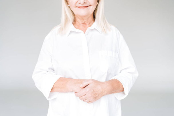cropped view of happy blonde senior woman in white clothes isolated on grey - Foto, Imagem