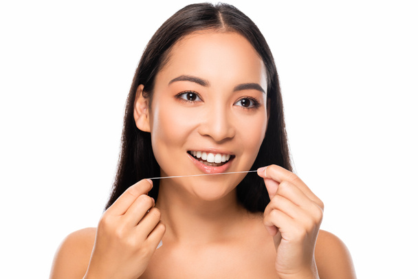 smiling asian naked woman holding dental floss isolated on white - Foto, afbeelding