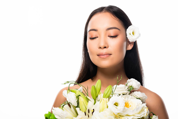 beautiful asian naked woman with flowers and closed eyes isolated on white - Фото, зображення