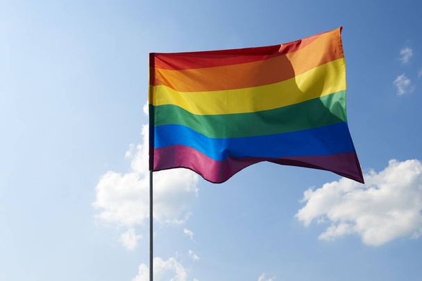 Tiro de ondear la bandera del arco iris fuera
  - Foto, imagen