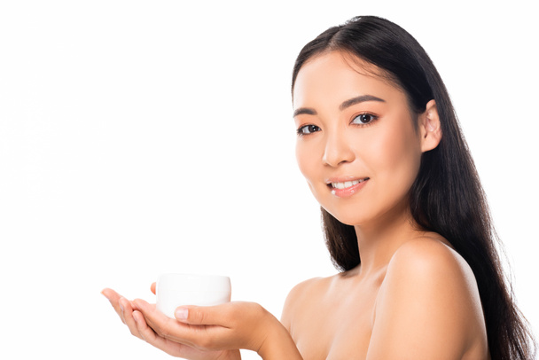 naakte mooie Aziatische vrouw houdt cosmetische crème geïsoleerd op wit - Foto, afbeelding