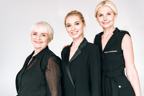 happy fashionable three-generation blonde women in total black outfits isolated on grey - Foto, Bild