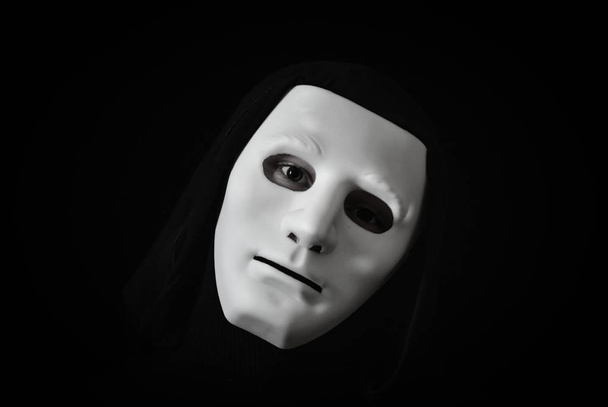 Ο άνθρωπος στο σκοτάδι με μια λευκή μάσκα - Φωτογραφία, εικόνα