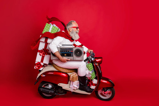Profile side view of his he nice attractive cheerful cheery funky bearded gray-haired man carrying cool desirable purchase things eve noel celebration isolated on bright vivid shine red background - Foto, imagen