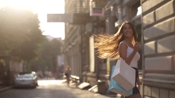 cheerful girl goes with shopping bags - Záběry, video