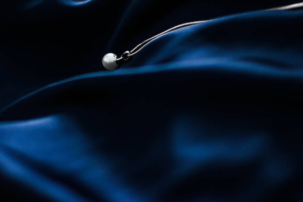 Luksusowy biały złoty naszyjnik perłowy na ciemnym niebieskim tle jedwabiu, h - Zdjęcie, obraz