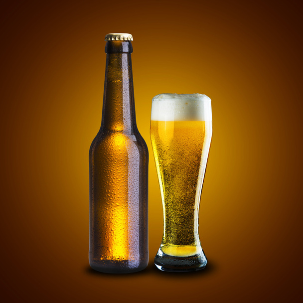 Bottle and Glass of cold beer on wood table with yellow grunge background - Photo, image