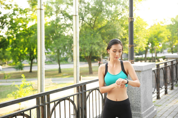Mulher asiática desportiva com rastreador de fitness ao ar livre
 - Foto, Imagem