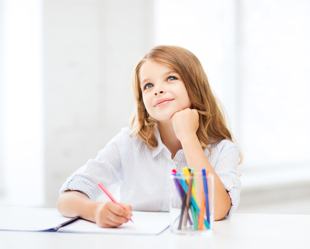 Little student girl drawing at school - Фото, изображение