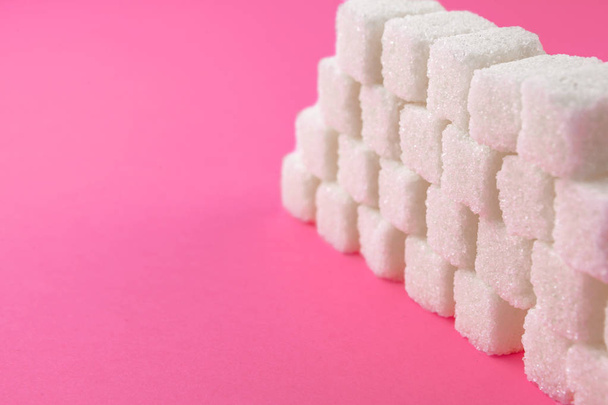Cubes of sugar on bright pink background - Fotoğraf, Görsel