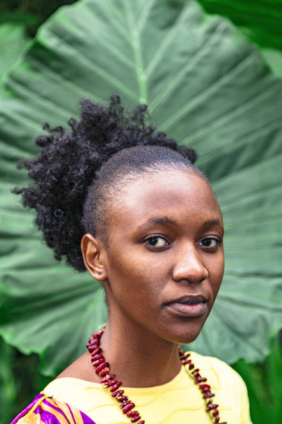 Young african woman on background of green tree - Φωτογραφία, εικόνα