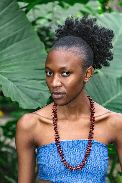 Portrait of african girl in blue top in jungle - Фото, зображення