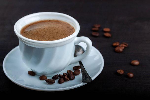 Cup of coffee on a black wooden table - Φωτογραφία, εικόνα