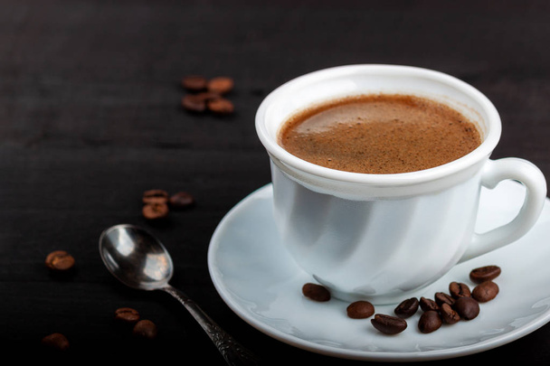 Cup of coffee on a black wooden table - Фото, зображення